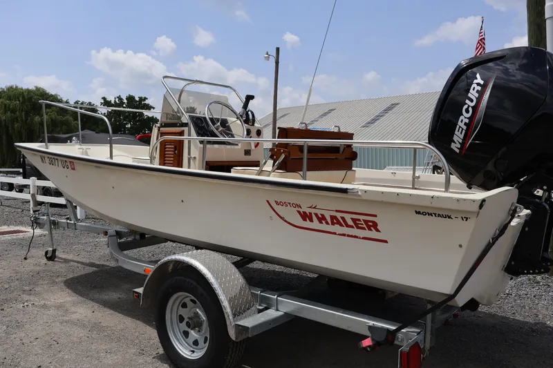 The Image of 1991 Boston Whaler 170 Montauk boat on trailer with Mercury outboard motor. - 0