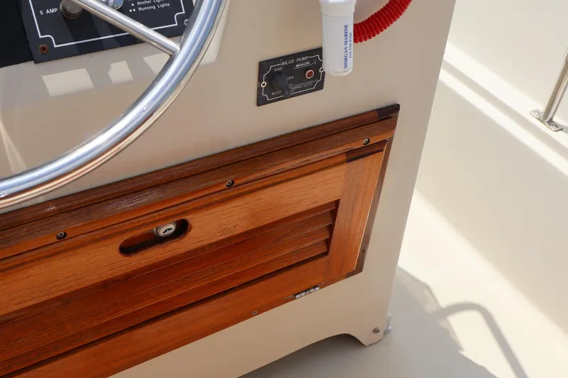 Slide: The Image of 1991 Boston Whaler 170 Montauk steering console with wooden panel and bilge pump switch. - 16