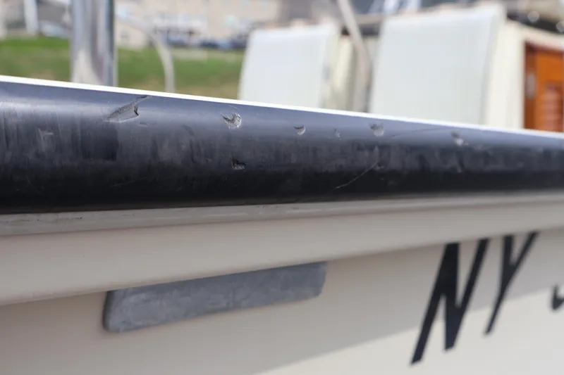 Slide: The Image of Close-up of 1991 Boston Whaler 170 Montauk boat with visible wear on the edge. - 29