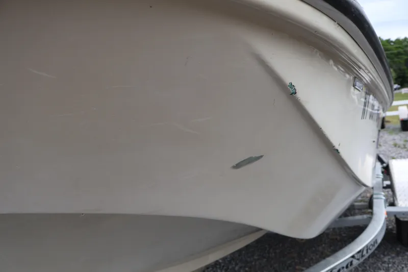 Slide: The Image of 1991 Boston Whaler 170 Montauk boat hull with visible scratches and paint chips. - 39