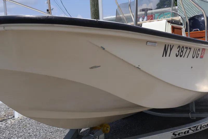 Slide: The Image of 1991 Boston Whaler 170 Montauk boat on trailer, showing hull and registration number. - 3