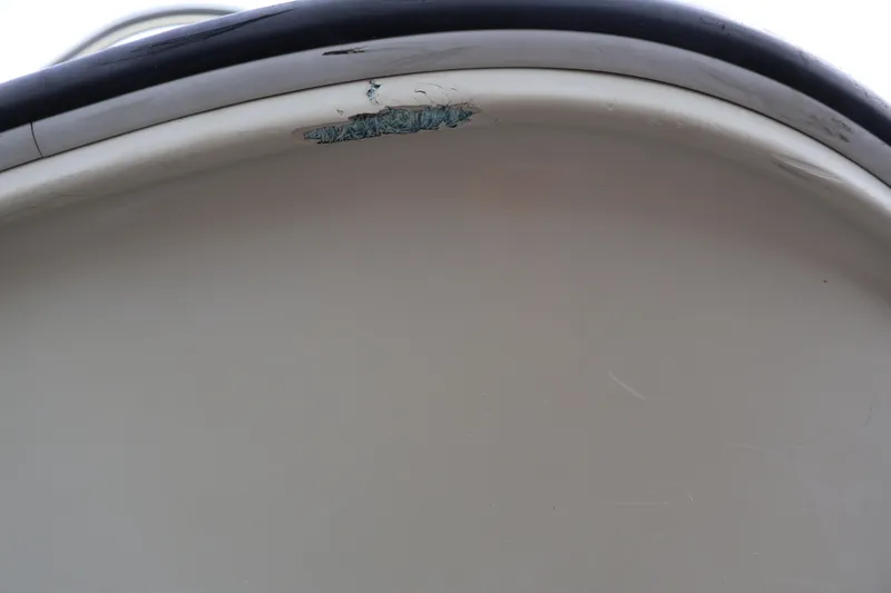 Slide: The Image of Close-up of a 1991 Boston Whaler 170 Montauk boat with visible hull damage. - 42