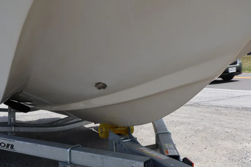 Slide: The Image of 1991 Boston Whaler 170 Montauk boat hull with visible damage on trailer. - 5
