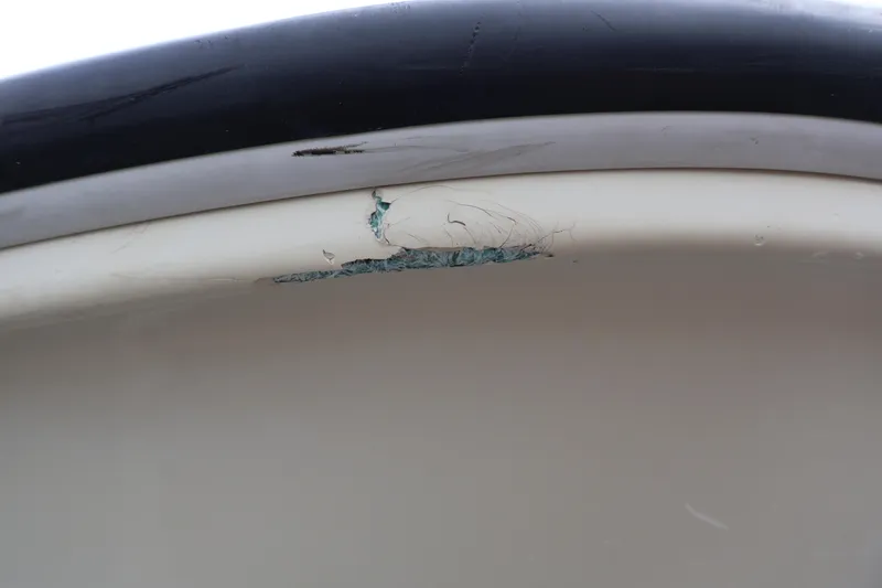 Slide: The Image of Close-up of damage on a 1991 Boston Whaler 170 Montauk boat hull. - 44