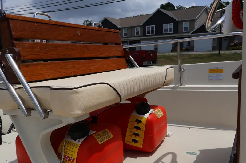Slide: The Image of 1991 Boston Whaler 170 Montauk interior with wooden bench and red fuel tanks. - 10