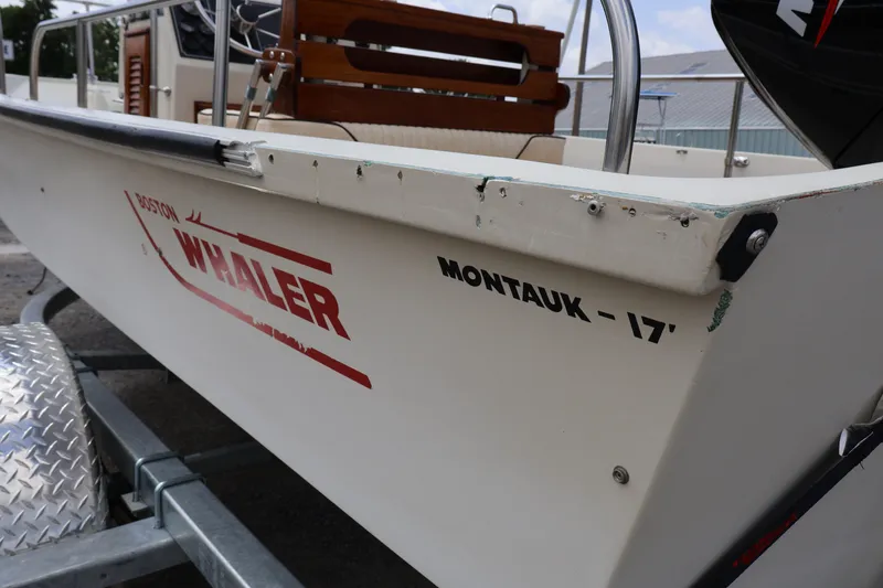 Slide: The Image of 1991 Boston Whaler 170 Montauk boat on trailer, side view with visible logo. - 7