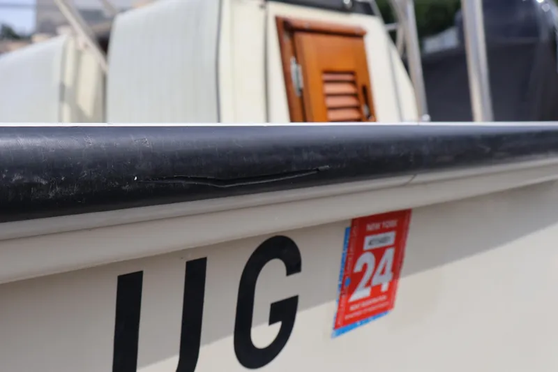 Slide: The Image of 1991 Boston Whaler 170 Montauk boat with New York registration sticker, close-up view. - 27