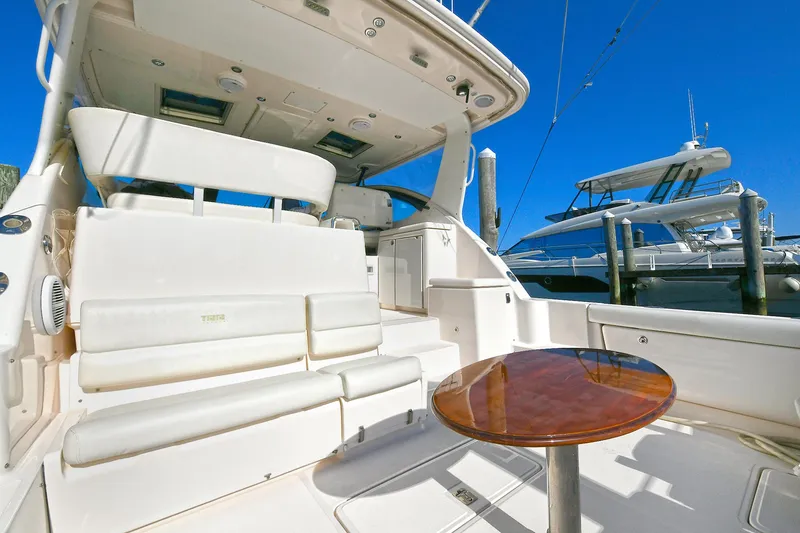 Slide: The Image of 2008 Tiara Yachts 4200 Open with spacious seating and table, docked under clear blue sky. - 8