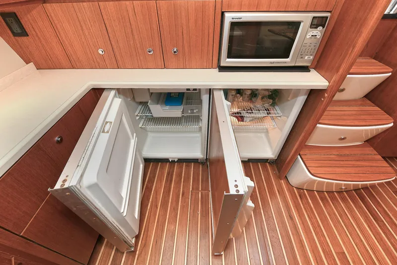 Slide: The Image of 2008 Tiara Yachts 4200 Open galley with open fridge, microwave, and wooden flooring. - 32