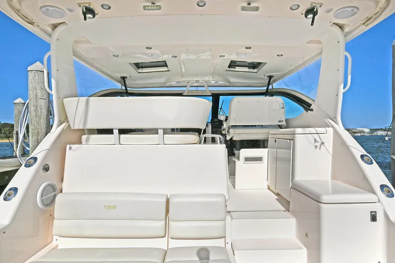Slide: The Image of 2008 Tiara Yachts 4200 Open interior with white seating and helm, docked by the water. - 6