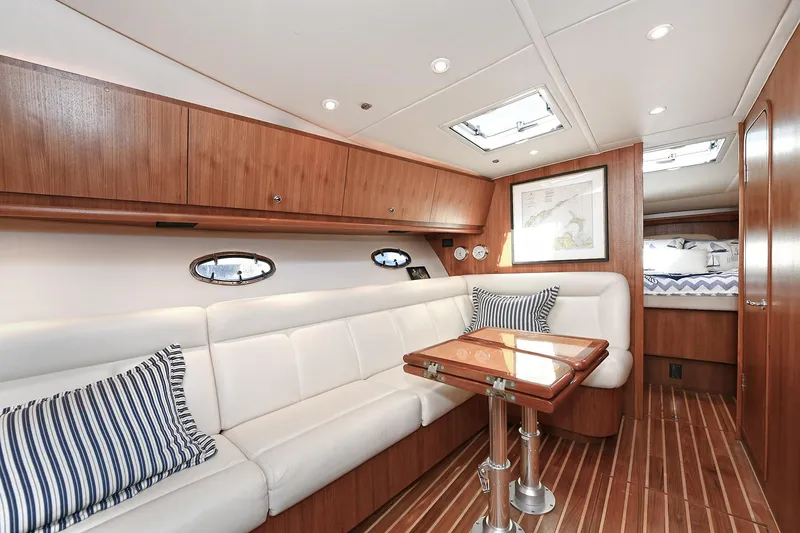 Slide: The Image of 2008 Tiara Yachts 4200 Open interior with white seating, wooden accents, and striped pillows. - 38