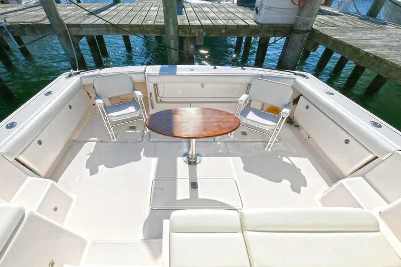 Slide: The Image of 2008 Tiara Yachts 4200 Open cockpit with seating and table, docked by the water. - 3