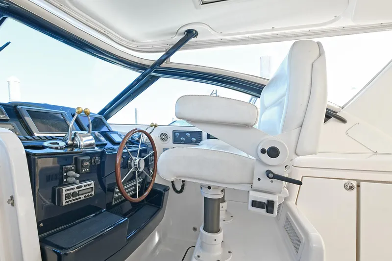 Slide: The Image of 2008 Tiara Yachts 4200 Open helm with white captain's chair and wooden steering wheel. - 22