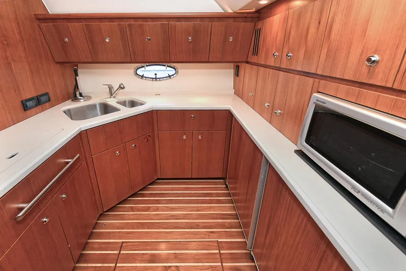 Slide: The Image of 2008 Tiara Yachts 4200 Open kitchen with wood cabinetry, stainless steel sink, and microwave. - 31
