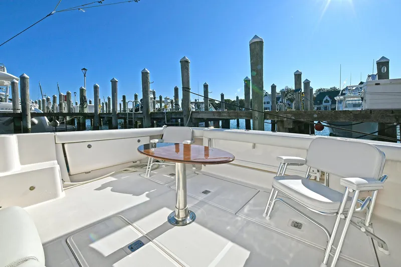 Slide: The Image of 2008 Tiara Yachts 4200 Open deck with seating and table, docked at marina. - 4