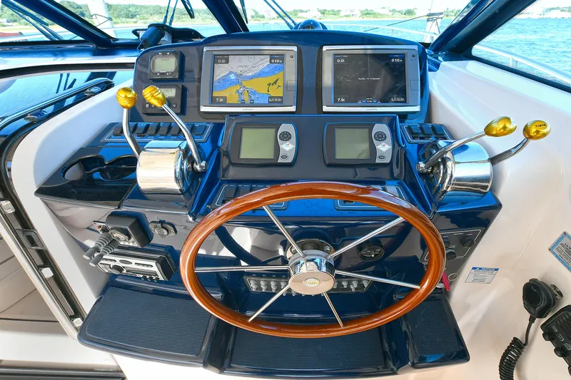 Slide: The Image of Helm of 2008 Tiara Yachts 4200 Open with navigation screens and wooden steering wheel. - 24