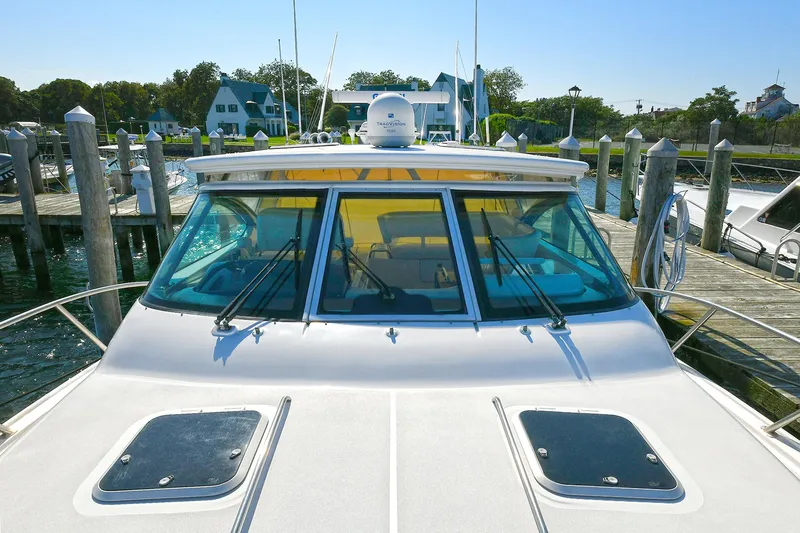 Slide: The Image of 2008 Tiara Yachts 4200 Open docked at marina, showcasing sleek design and spacious deck. - 14