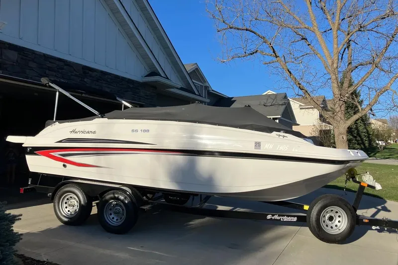 The Image of 2020 Hurricane SunDeck Sport 188 IO boat on trailer, parked in residential driveway. - 0