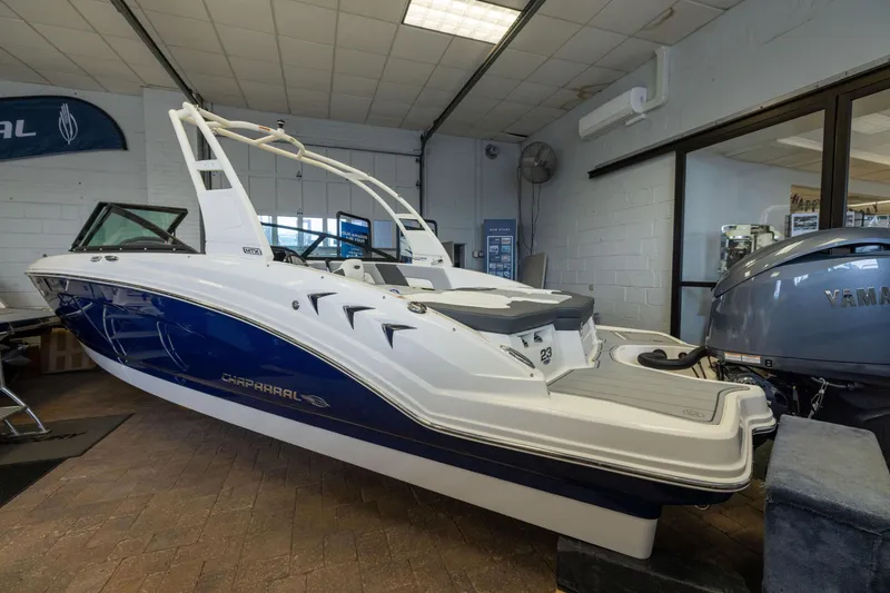 The Image of 2026 Chaparral 23 SSi OB boat displayed indoors, featuring sleek design and modern outboard motor. - 1