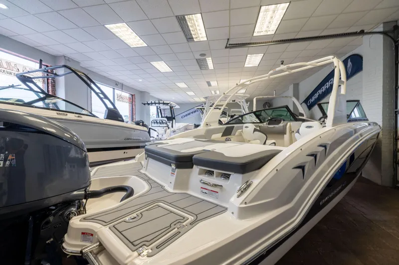 Slide: The Image of 2026 Chaparral 23 SSi OB boat displayed in a showroom, showcasing sleek design and modern features. - 2