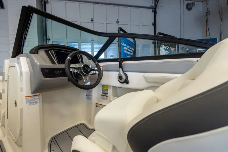 Slide: The Image of Interior view of 2026 Chaparral 23 SSi OB boat, featuring sleek steering and modern design. - 18