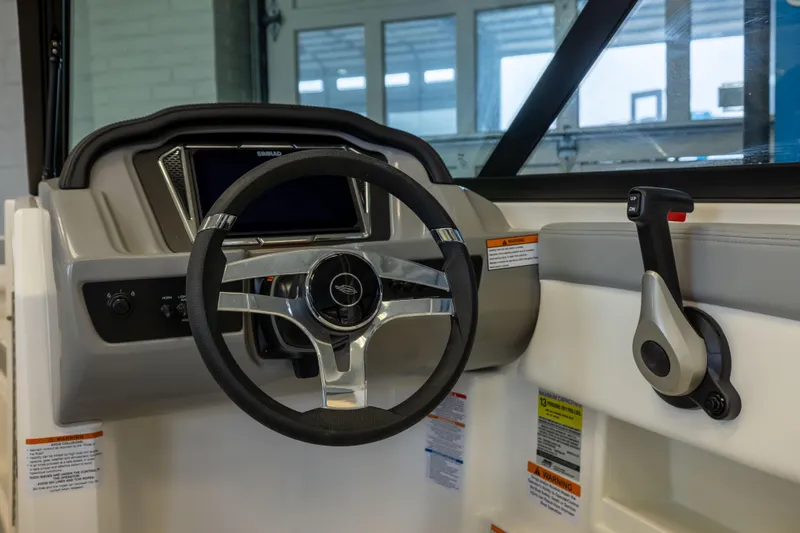 Slide: The Image of 2026 Chaparral 23 SSi OB boat dashboard with steering wheel and control lever. - 15