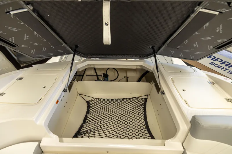 Slide: The Image of 2026 Chaparral 23 SSi OB boat storage compartment with open hatch and netting. - 20