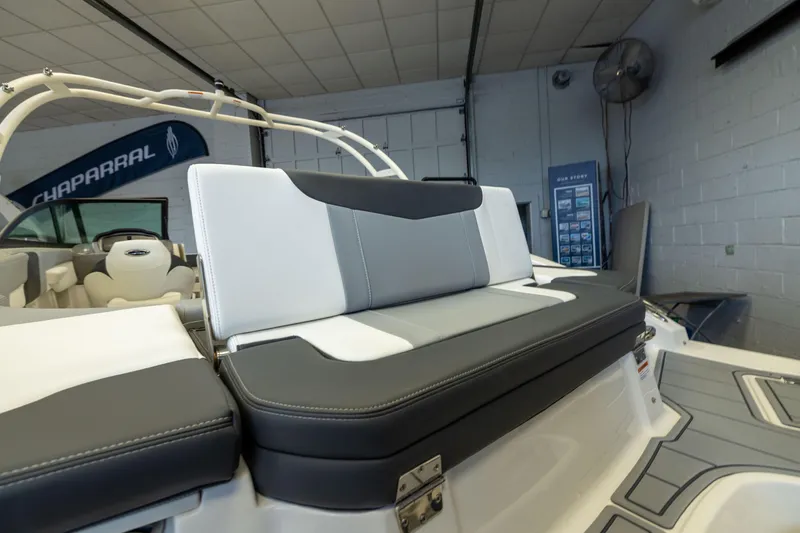 Slide: The Image of 2026 Chaparral 23 SSi OB boat interior with sleek seating design in showroom. - 7
