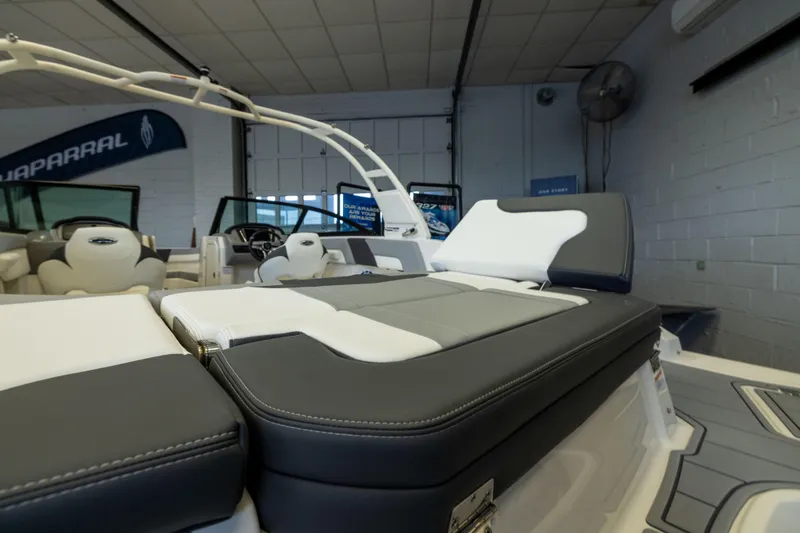 Slide: The Image of 2026 Chaparral 23 SSi OB boat interior with cushioned seating in showroom. - 8