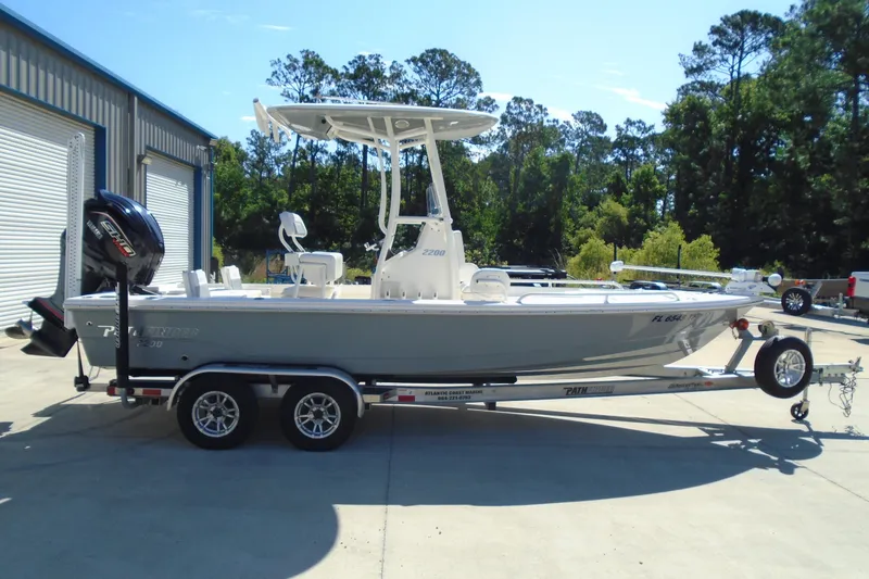 Slide: The Image of 2022 Pathfinder 2200 TRS boat on trailer, parked outdoors near a building. - 2