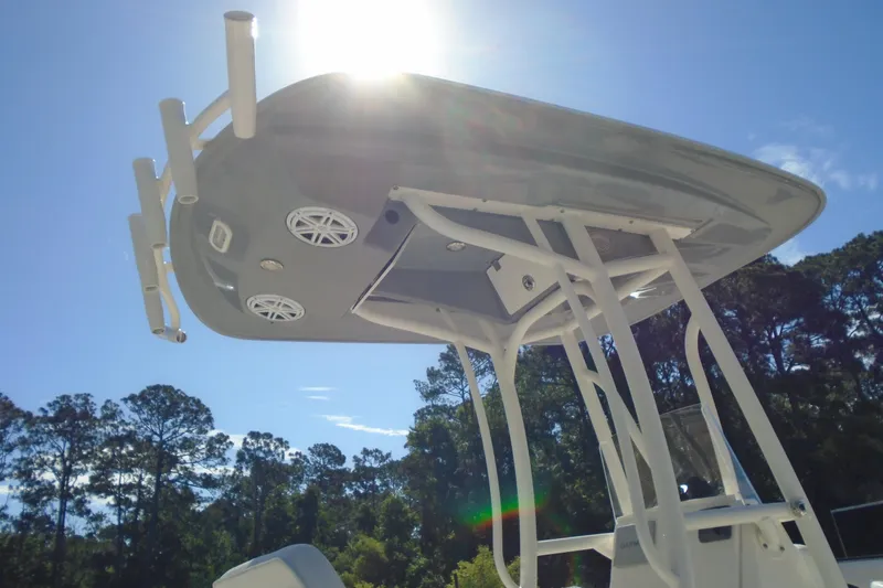 Slide: The Image of 2022 Pathfinder 2200 TRS boat with T-top under bright sun, surrounded by trees. - 14