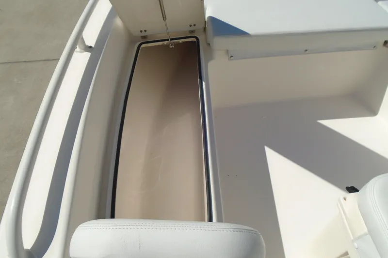 Slide: The Image of 2022 Pathfinder 2200 TRS boat interior storage compartment, white seating, and clean design. - 28