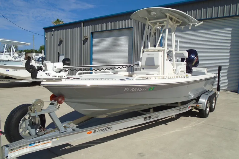 Slide: The Image of 2022 Pathfinder 2200 TRS boat on trailer, parked outside a metal building. - 4