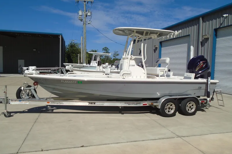 Slide: The Image of 2022 Pathfinder 2200 TRS boat on trailer, parked outside a warehouse. - 5