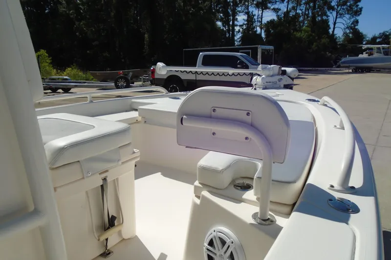 Slide: The Image of 2022 Pathfinder 2200 TRS boat interior with seating and storage, parked outdoors. - 15