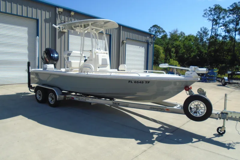 Slide: The Image of 2022 Pathfinder 2200 TRS boat on trailer, parked outside a warehouse. - 1