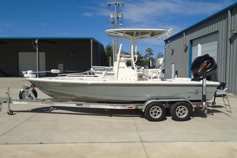 Slide: The Image of 2022 Pathfinder 2200 TRS boat on trailer, parked outside industrial building. - 16