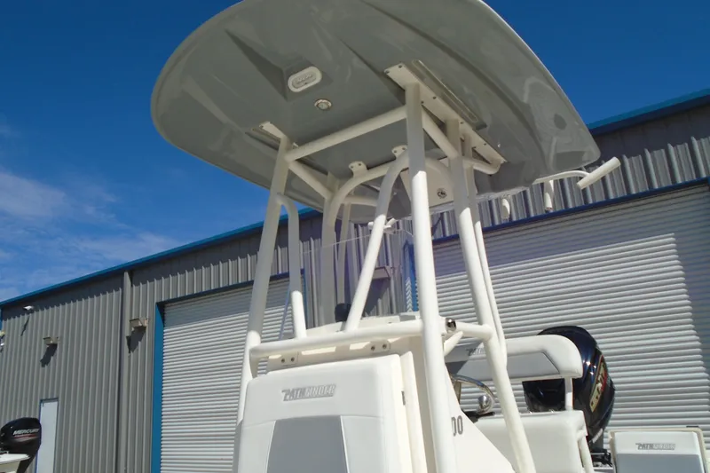 Slide: The Image of 2022 Pathfinder 2200 TRS boat with T-top, parked near a metal building. - 20