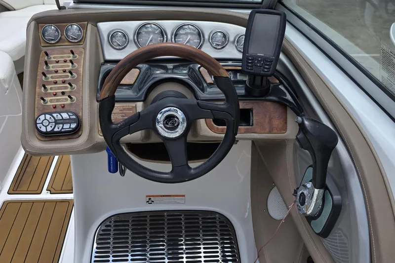 Slide: The Image of 2006 Cobalt 272 boat dashboard with steering wheel, gauges, and navigation system. - 13