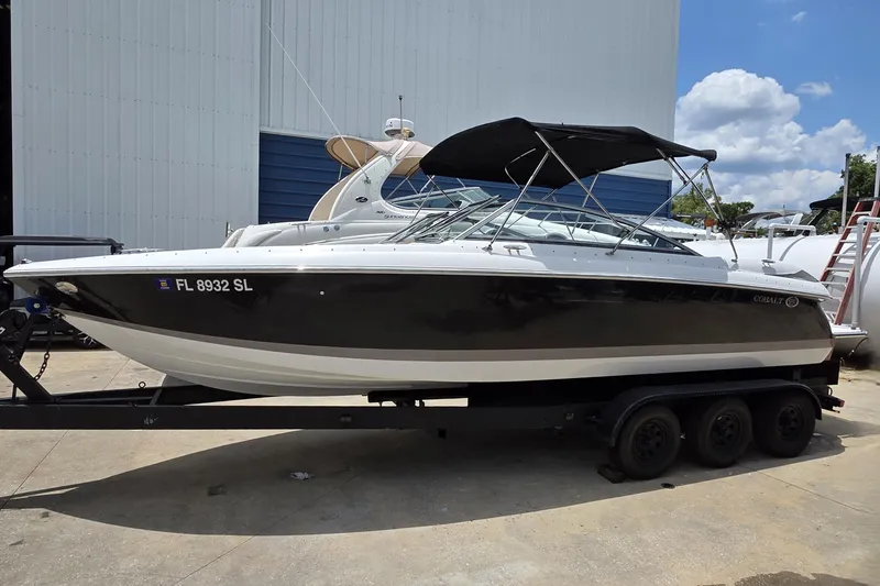 The Image of 2006 Cobalt 272 boat on trailer, black and white exterior, parked outdoors. - 0