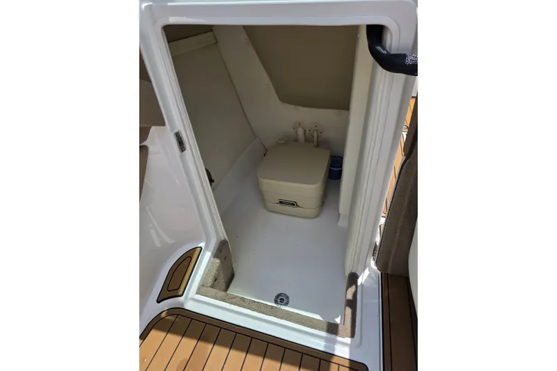 Slide: The Image of 2006 Cobalt 272 boat interior with compact marine toilet and storage space. - 23