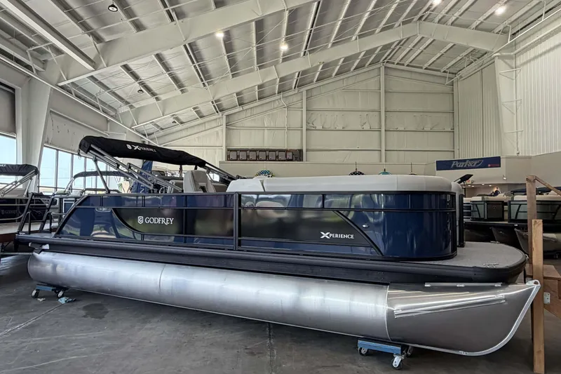 Slide: The Image of 2027 Godfrey EX 2286 SFLX pontoon boat displayed in a spacious indoor showroom. - 3