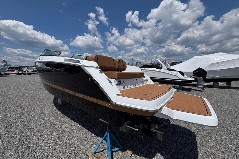 Slide: The Image of 2026 Four Winns H6 boat with sleek design, parked outdoors under a blue sky. - 4