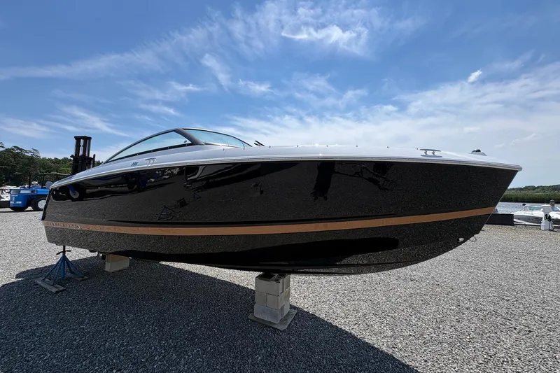 The Image of 2026 Four Winns H6 boat displayed outdoors on gravel under a clear blue sky. - 0