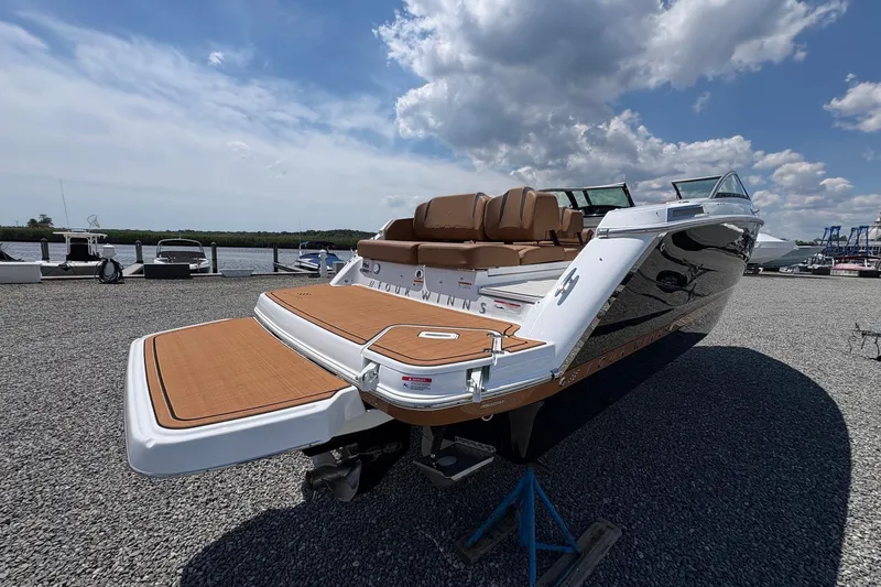 Slide: The Image of 2026 Four Winns H6 boat with sleek design, docked under a partly cloudy sky. - 6