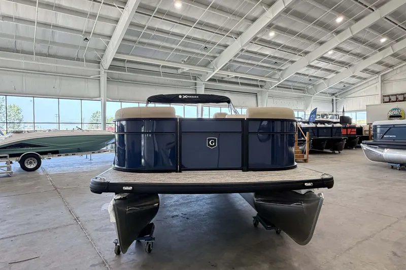 Slide: The Image of 2027 Godfrey EX 2286 SBX pontoon boat displayed in a spacious indoor showroom. - 1
