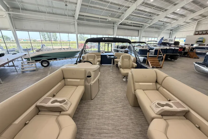 Slide: The Image of Luxurious 2027 Godfrey EX 2286 SBX pontoon boat interior in showroom setting. - 2