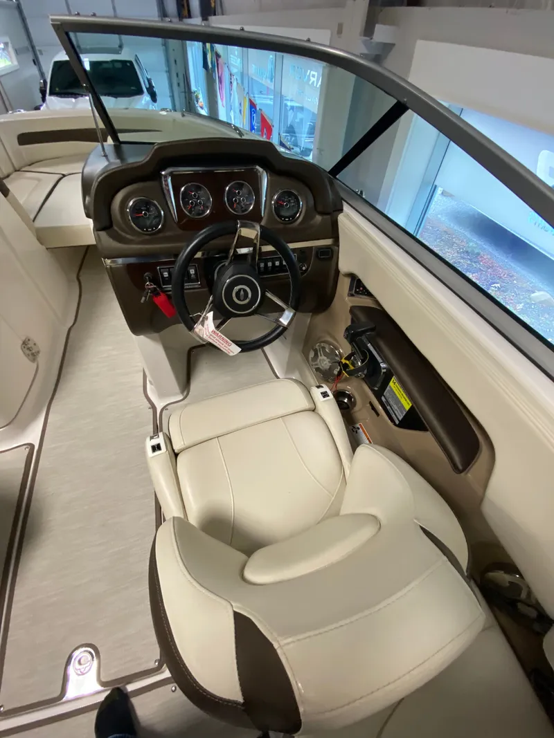Slide: The Image of Interior view of a 2020 Chaparral 24 SSI with cream seats and a modern dashboard. - 3