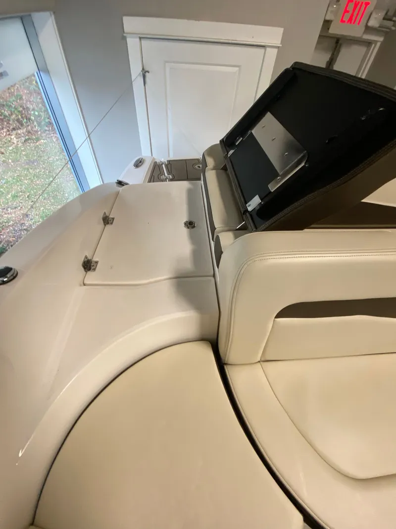 Slide: The Image of Interior view of a 2020 Chaparral 24 SSI with beige upholstery and storage compartment. - 22