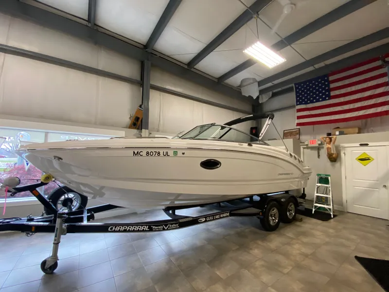 Slide: The Image of A 2020 Chaparral 24 SSI boat on a trailer inside a showroom. - 8